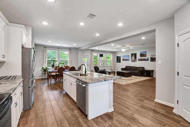 30000 Round Up Dr, Waller, TX 77484 - kitchen with white cabinetry, light stone countertops, visible vents, appliances with stainless steel finishes, and wood finished floors