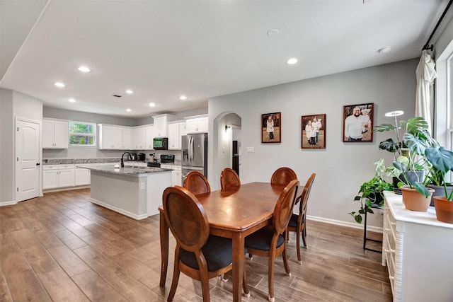 30000 Round Up Dr, Waller, TX 77484 - dining space with light wood-style flooring, arched walkways, baseboards, and recessed lighting