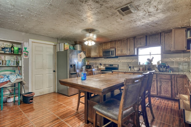 kitchen with tasteful backsplash, visible vents, ceiling fan, appliances with stainless steel finishes, and dark wood-style floors