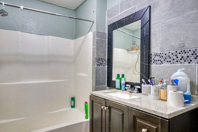 full bathroom featuring vanity,  shower combination, tile walls, and decorative backsplash