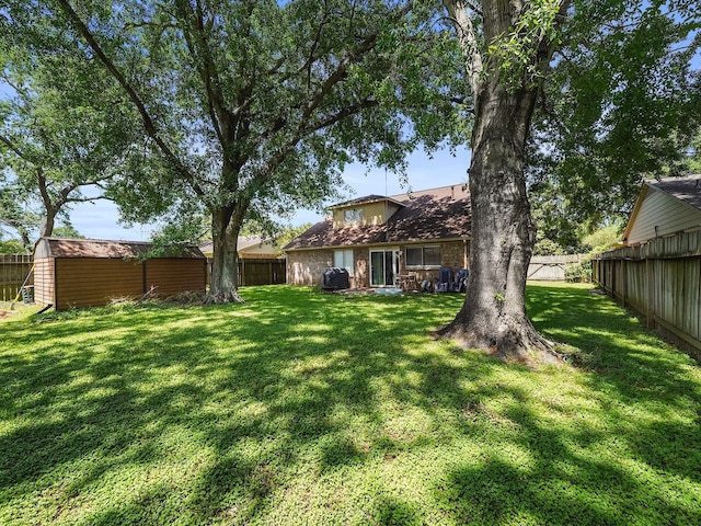 22403 Red River Dr, Katy, TX 77450 - view of yard featuring a shed, a fenced backyard, and an outdoor structure
