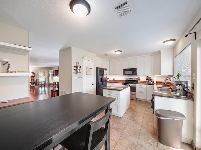 22403 Red River Dr, Katy, TX 77450 - kitchen featuring white cabinetry, visible vents, black appliances, a sink, and dark countertops