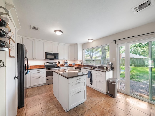 22403 Red River Dr, Katy, TX 77450 - kitchen with a sink, visible vents, black appliances, and white cabinetry