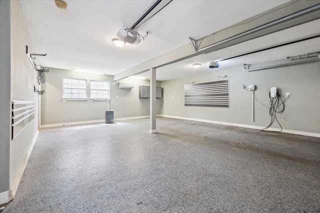 garage featuring a wall mounted AC, baseboards, and a garage door opener