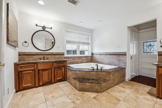 bathroom featuring visible vents, recessed lighting, vanity, and a garden tub