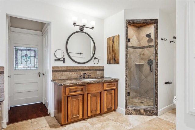 full bath featuring tasteful backsplash, vanity, a stall shower, tile patterned floors, and toilet