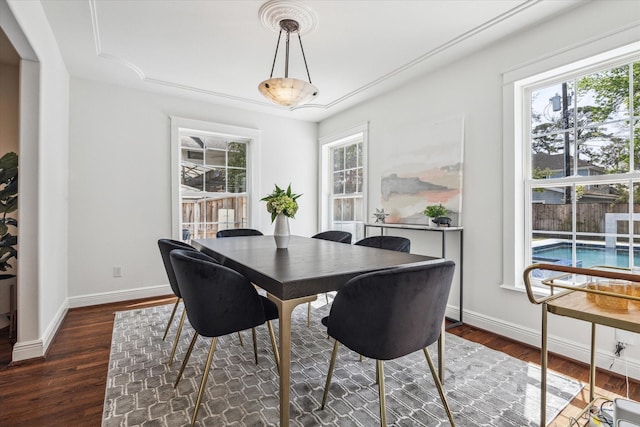 dining space with baseboards and wood finished floors