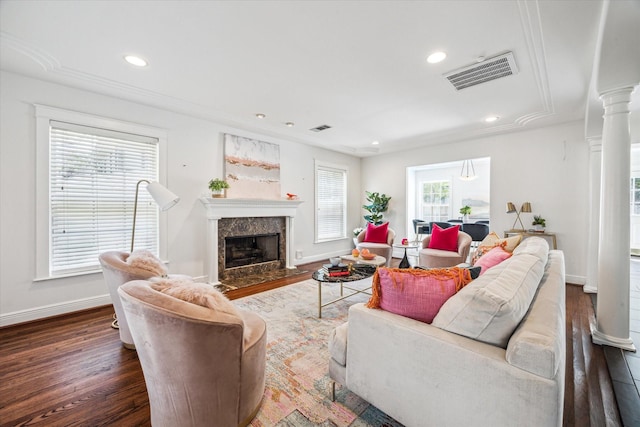living room with baseboards, visible vents, ornate columns, a high end fireplace, and wood finished floors