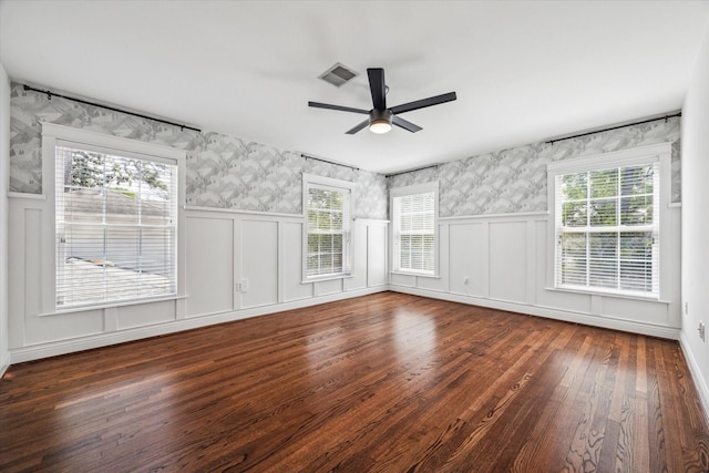 spare room with wallpapered walls, ceiling fan, wood finished floors, and a decorative wall