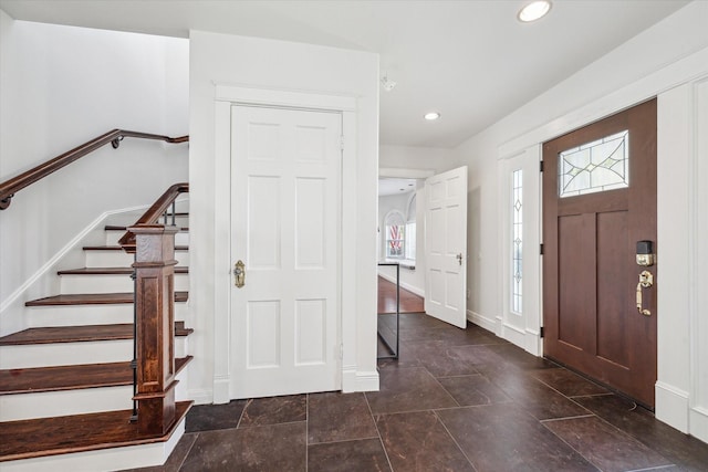 foyer featuring baseboards, recessed lighting, and stairs