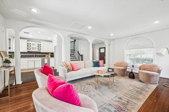 living room featuring visible vents, arched walkways, decorative columns, recessed lighting, and stairway