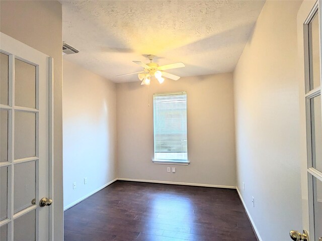 unfurnished room featuring visible vents, wood finished floors, baseboards, ceiling fan, and a textured ceiling