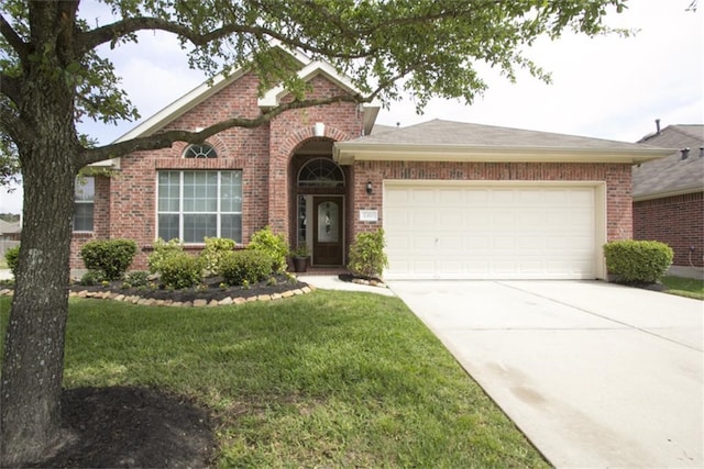 view of front of home featuring brick siding, a garage, a front lawn, and concrete driveway