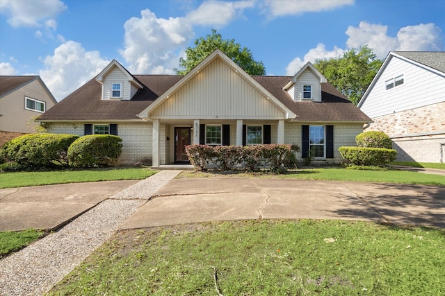 5731 S Braeswood Blvd, Houston, TX 77096 - view of front of property with a shingled roof, a porch, brick siding, and a front lawn