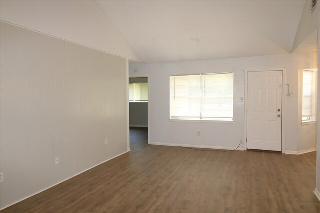 unfurnished living room with lofted ceiling, dark wood-type flooring, and baseboards