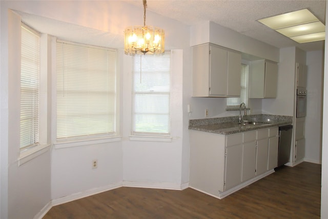 kitchen with a sink, a chandelier, dark wood finished floors, baseboards, and dishwashing machine