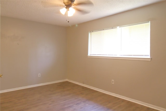 empty room with ceiling fan, baseboards, wood finished floors, and a textured ceiling
