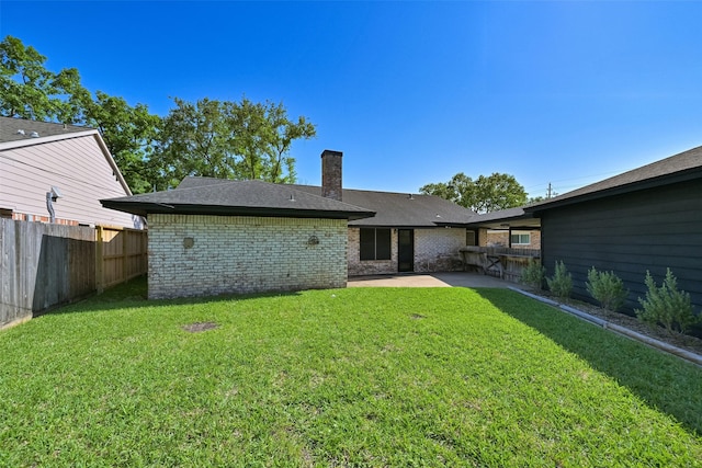 154 Camellia St, Sugar Land, TX 77478 - back of property featuring a patio, a chimney, brick siding, and roof with shingles