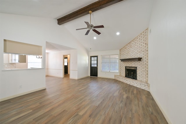 154 Camellia St, Sugar Land, TX 77478 - unfurnished living room featuring beamed ceiling, a ceiling fan, wood finished floors, a fireplace, and high vaulted ceiling