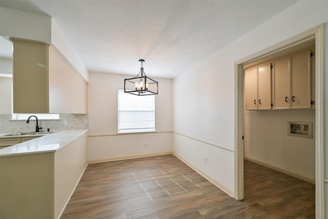 154 Camellia St, Sugar Land, TX 77478 - unfurnished dining area with a sink, wood finished floors, a chandelier, and baseboards