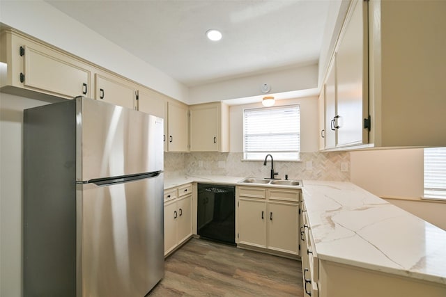 154 Camellia St, Sugar Land, TX 77478 - kitchen with dishwasher, freestanding refrigerator, a sink, wood finished floors, and tasteful backsplash