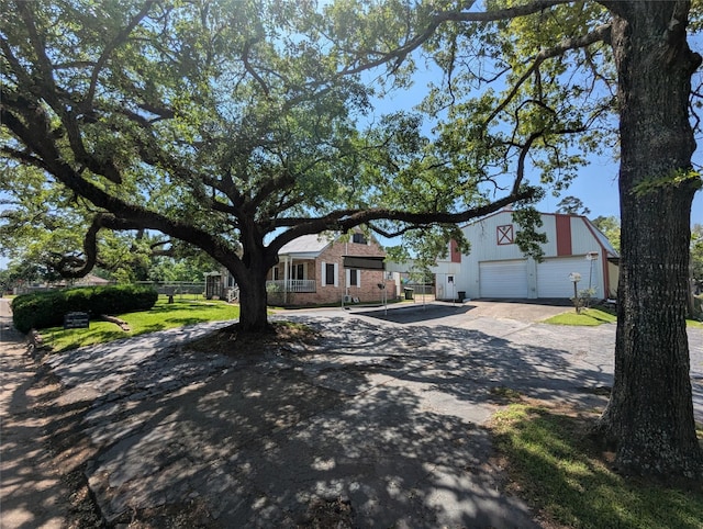 view of front facade featuring brick siding, concrete driveway, and fence