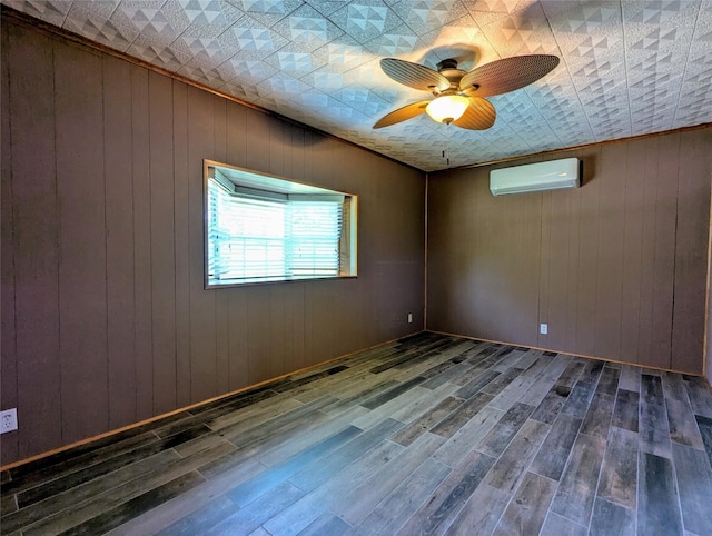 unfurnished room with wood walls, a ceiling fan, wood finished floors, and a wall mounted air conditioner