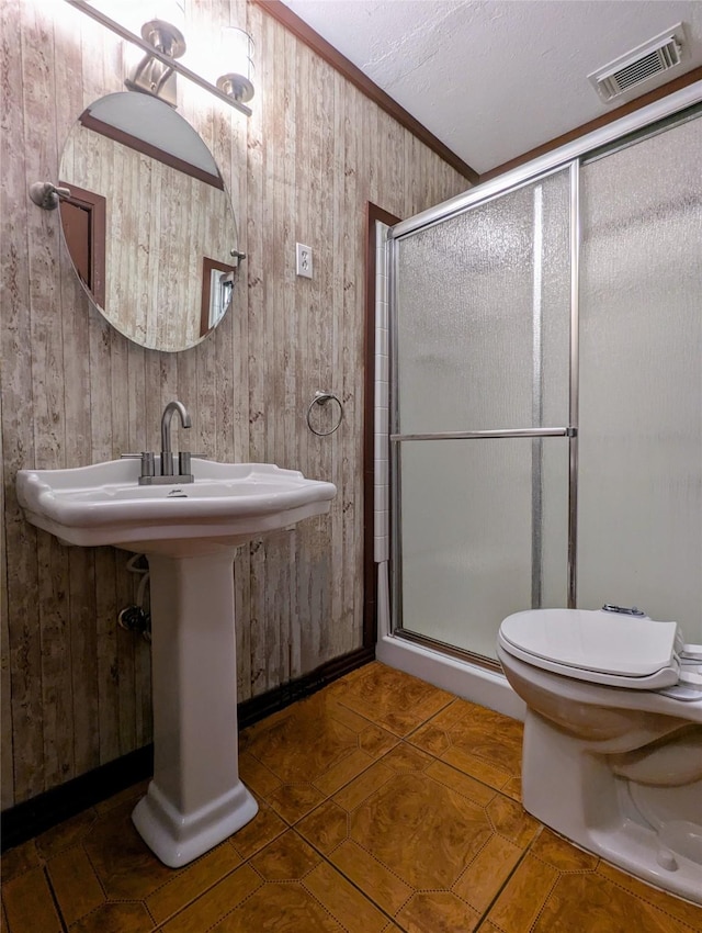 full bathroom featuring wooden walls, visible vents, and a stall shower