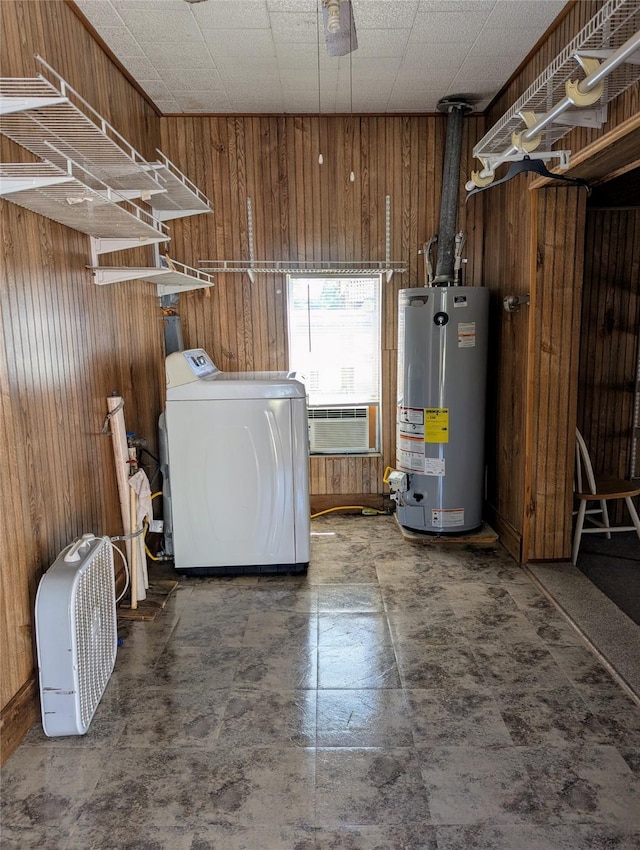 laundry area with a wall mounted air conditioner, water heater, wooden walls, laundry area, and washer / dryer