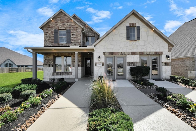 19407 Sorrel Stallion Trl, Tomball, TX 77377 - view of front facade with french doors, fence, stone siding, and brick siding