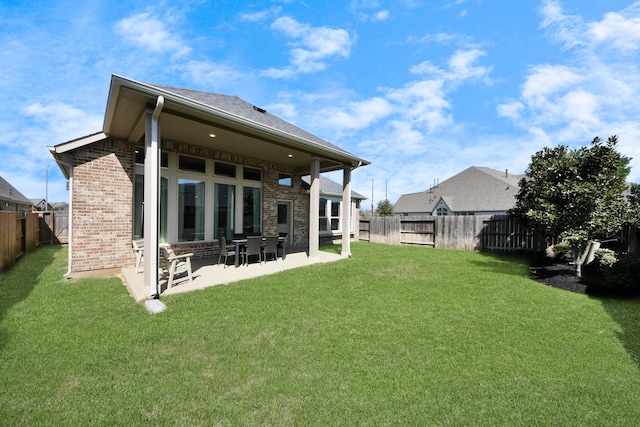 19407 Sorrel Stallion Trl, Tomball, TX 77377 - rear view of house featuring a lawn, a fenced backyard, a patio area, and brick siding