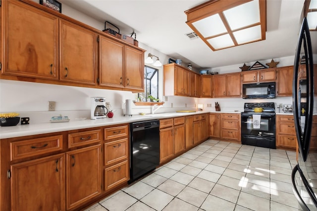 221 Kokomo Run, Point Blank, TX 77364 - kitchen featuring brown cabinetry, light tile patterned flooring, light countertops, and black appliances