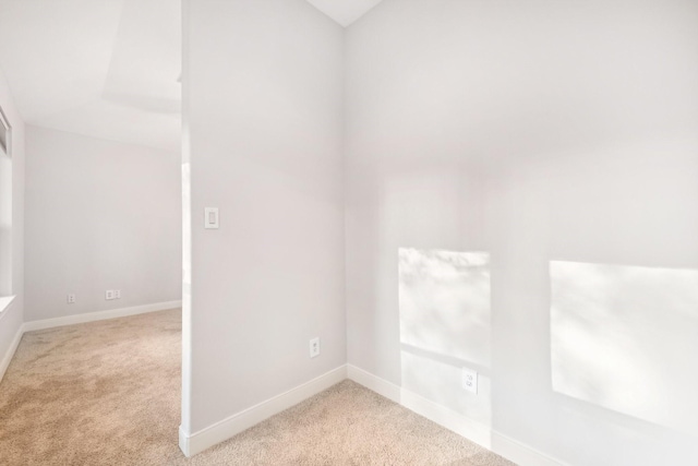 empty room featuring baseboards and carpet flooring