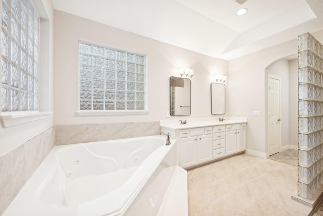 bathroom featuring a tray ceiling, tile patterned flooring, visible vents, a whirlpool tub, and double vanity