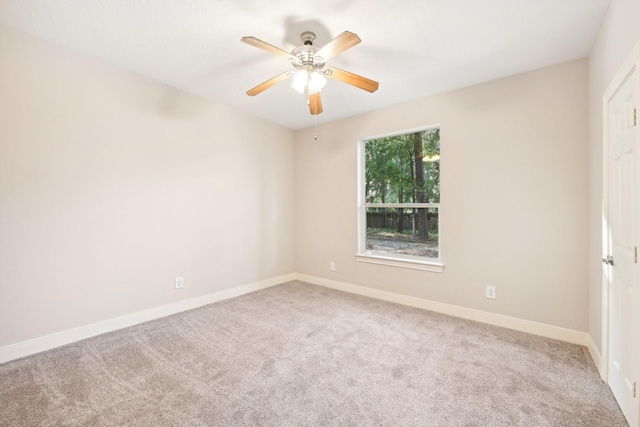 spare room featuring baseboards, a ceiling fan, and carpet