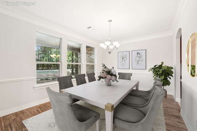 dining space with crown molding, an inviting chandelier, dark wood-type flooring, visible vents, and baseboards