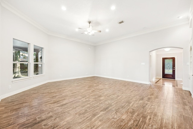 interior space featuring arched walkways, wood finished floors, a ceiling fan, and visible vents