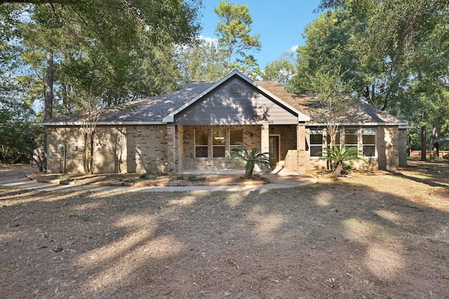 view of front facade featuring brick siding and covered porch