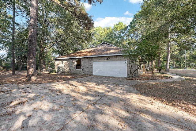 view of side of home with an attached garage and driveway