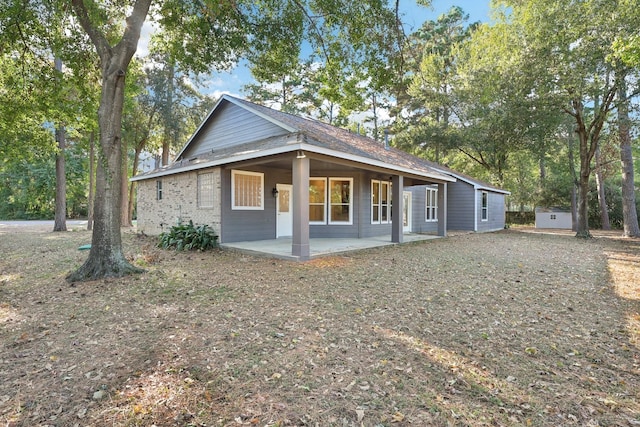 back of house with an outbuilding and a patio area