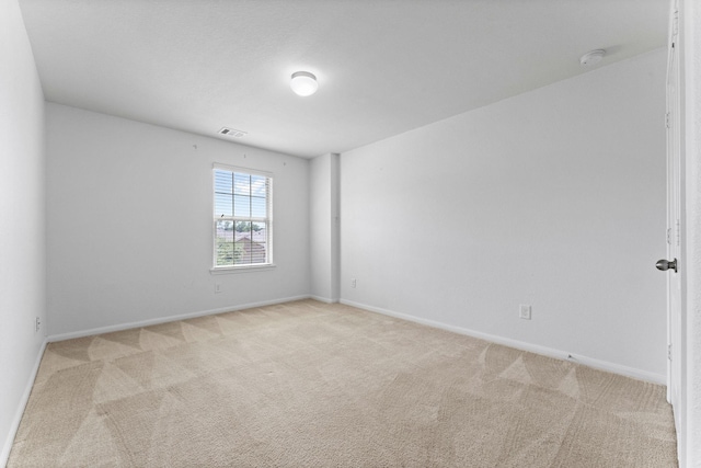 unfurnished room with light colored carpet, baseboards, and visible vents