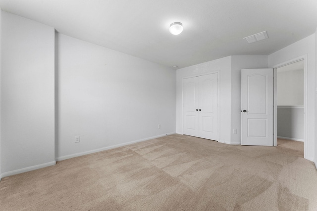 unfurnished bedroom featuring a closet, baseboards, carpet flooring, and visible vents
