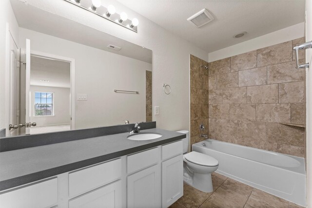 bathroom with washtub / shower combination, vanity, toilet, and visible vents