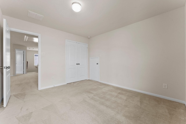unfurnished bedroom featuring light colored carpet, baseboards, visible vents, and a closet