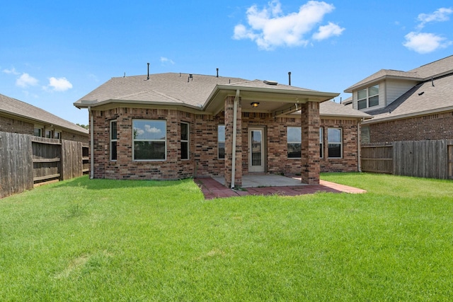 rear view of house featuring a fenced backyard, a lawn, a patio area, and brick siding