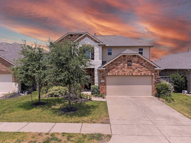 view of front of house featuring a lawn, an attached garage, stone siding, and concrete driveway