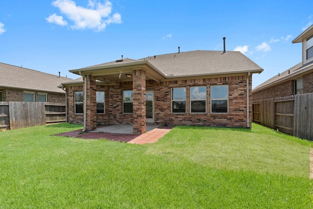 back of house featuring a patio, brick siding, a fenced backyard, and a lawn