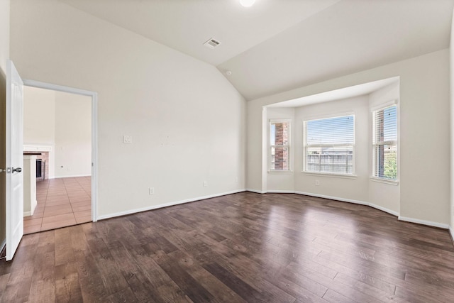 unfurnished room featuring baseboards, vaulted ceiling, dark wood finished floors, and visible vents