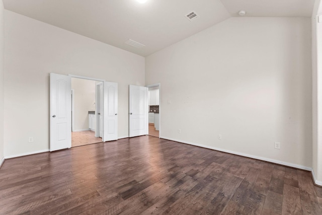 unfurnished bedroom featuring baseboards, dark wood-style flooring, high vaulted ceiling, and visible vents