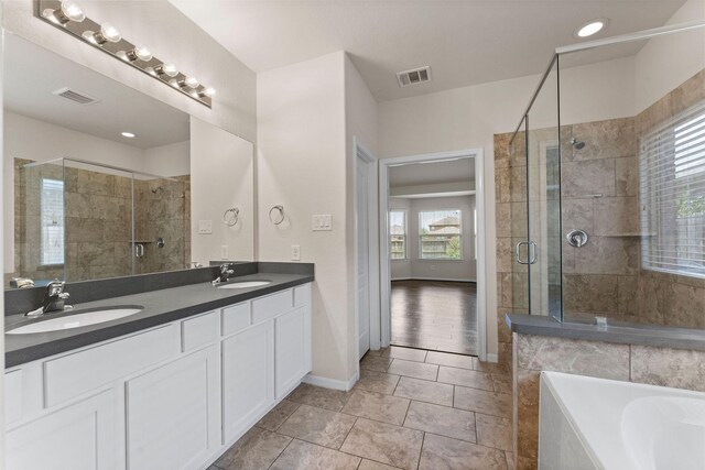 bathroom featuring visible vents, a sink, and a stall shower